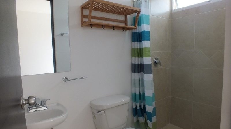 Bathroom with a toilet and blue shower curtain at Punta Estrella