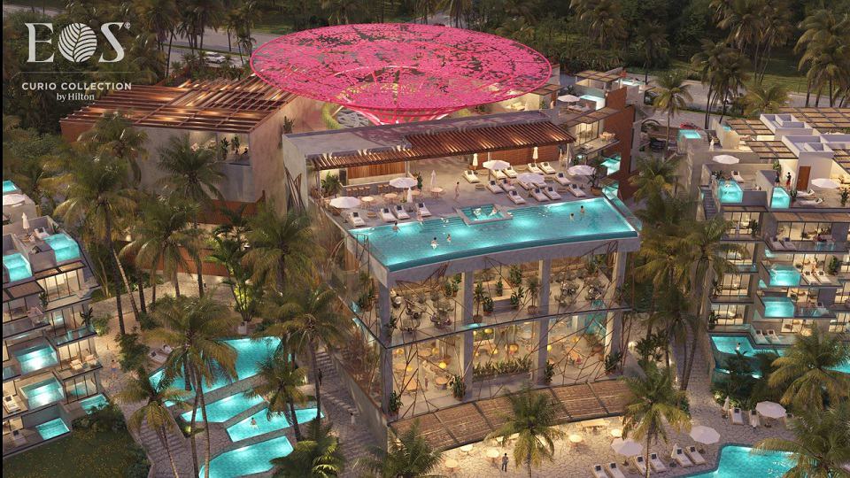 View of residential towers with pool complex and pink flower construction at Eos Tulum