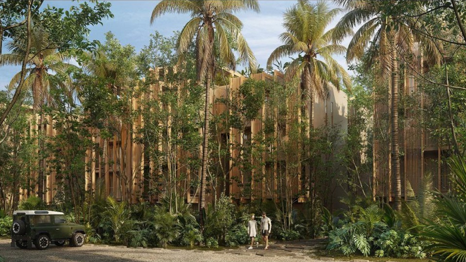 Residential towers surrounded by jungle and a couple walking to the parking lot at Aflora Tulum
