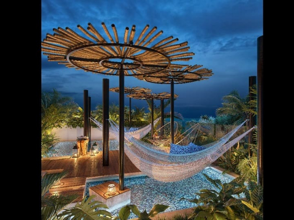 Small pools and hammocks and round pergolas at night at Piedrazul Downtown