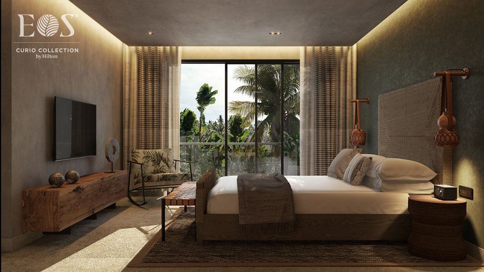 Large bedroom with a bed in front of tv screen at Eos Tulum