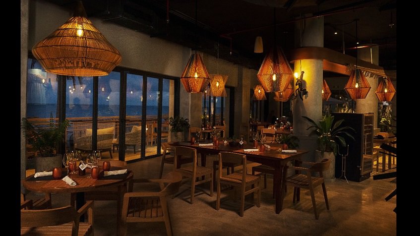 Night view of restaurant with ocean view terrace at The Fives Oceanfront