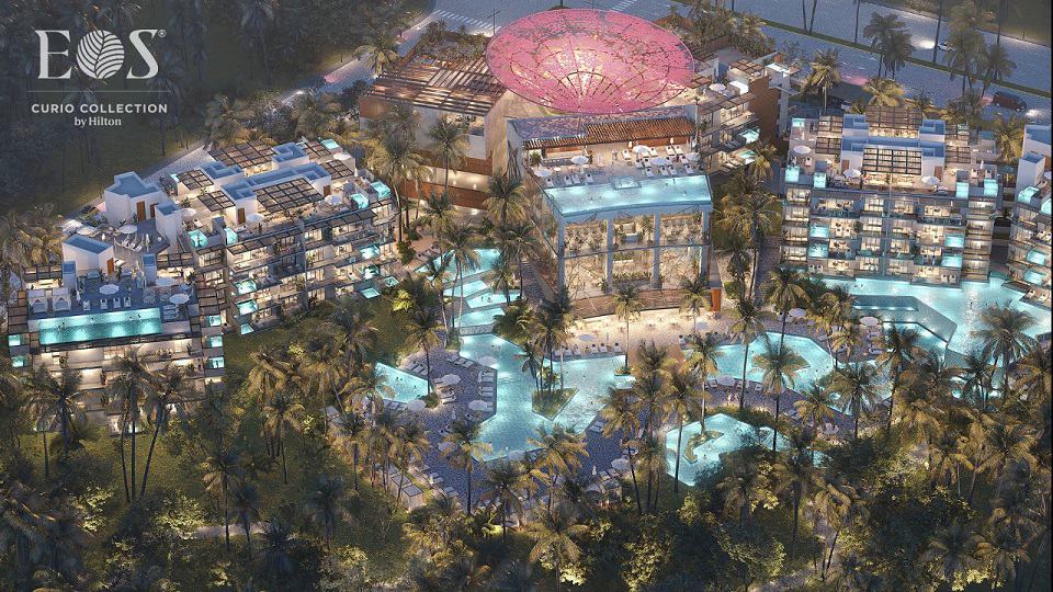 View of illuminated residential towers with pool complex at Eos Tulum