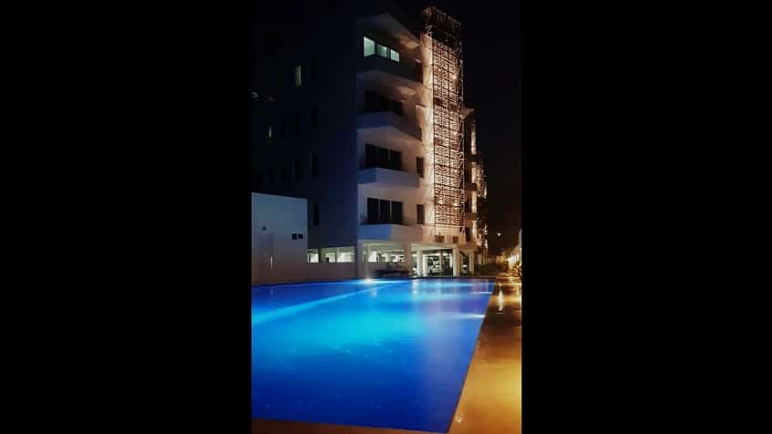 Night view of a ground floor swimming pool with white building on the side at StarLight Towers