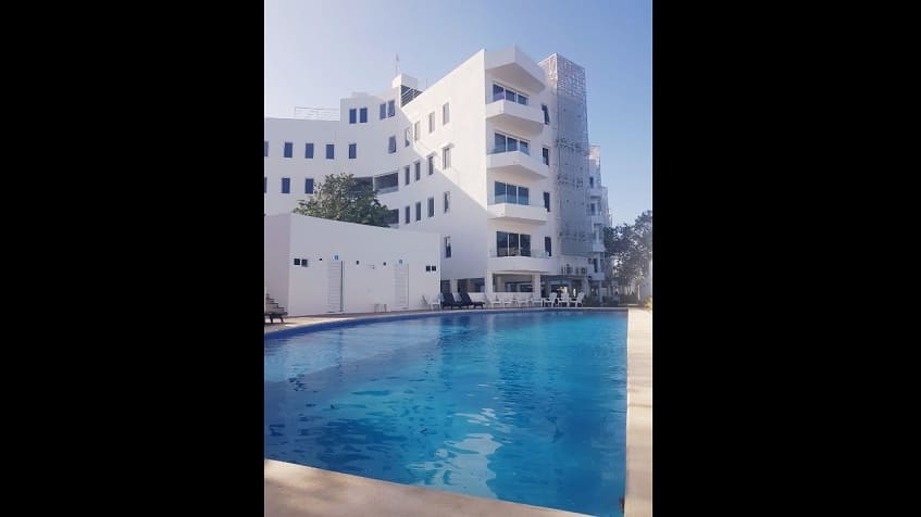 Ground floor swimming pool with white building on the side at StarLight Towers