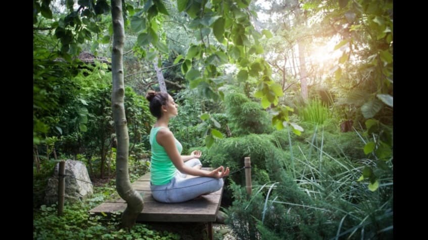 Terrace with woman doing yoga outdoors in the jungle at Kuyabeh Tulum