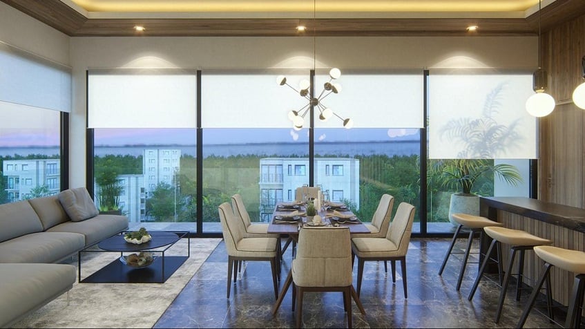 Studio condo interior with glass wall corner, sofa and large dining table at Musa del Carmen