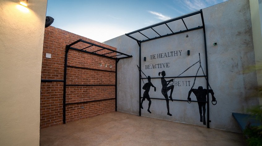 Crossfit area in the rooftop with wall poster: be healthy, be active,be it at Believe Playa Condos