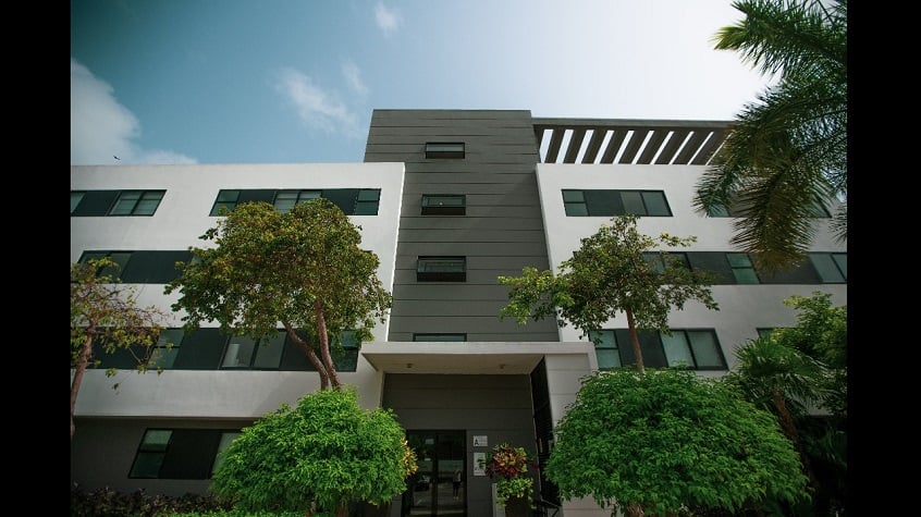 Residential building facade with main door surrounded by trees at Nick Price Residences