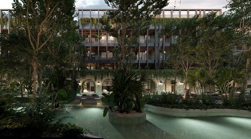 Night view of swimming pool and arcade facade building surrounded by vegetation at Hacienda Tuk