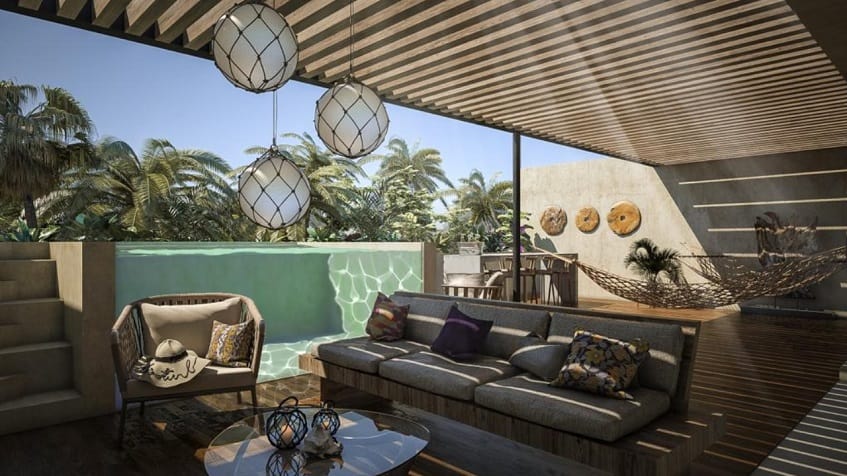 Penthouse terrace with sofas, hammocks and glass wall pool at Ophelia Tulum