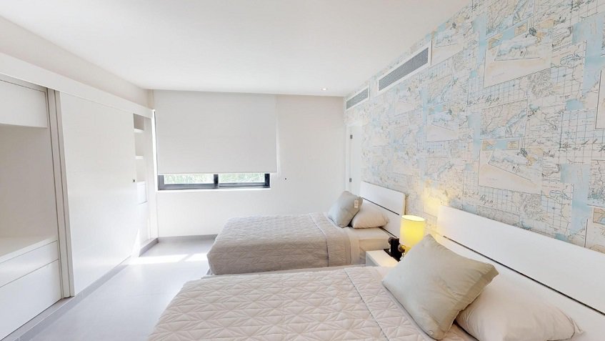 Bright bedroom with two double beds and small window at Nick Price Residences