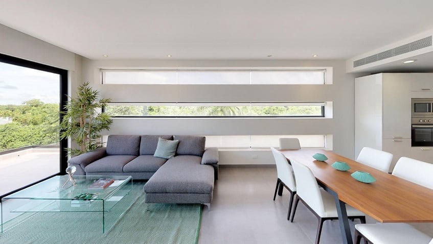Living room and dining table with long horizontal windows at Nick Price Residences