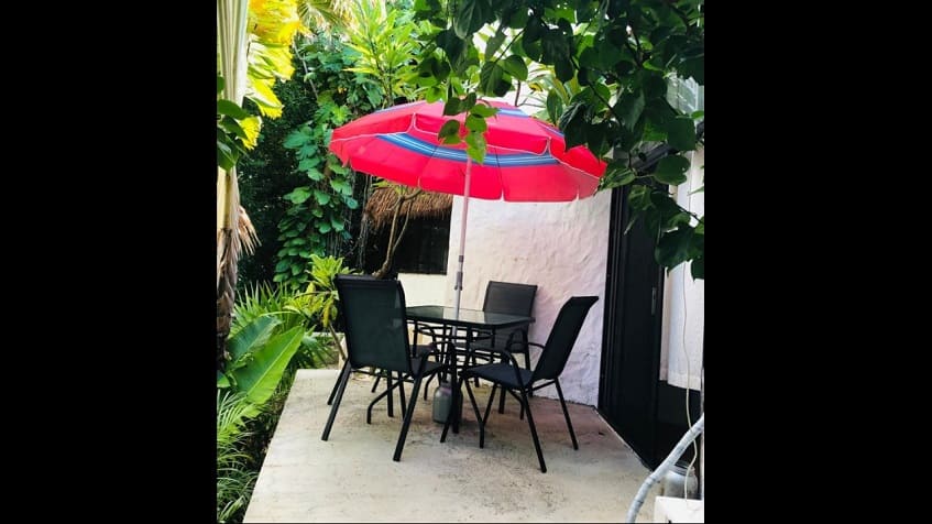 Terrace with garden table with red umbrella at Casa Playacar