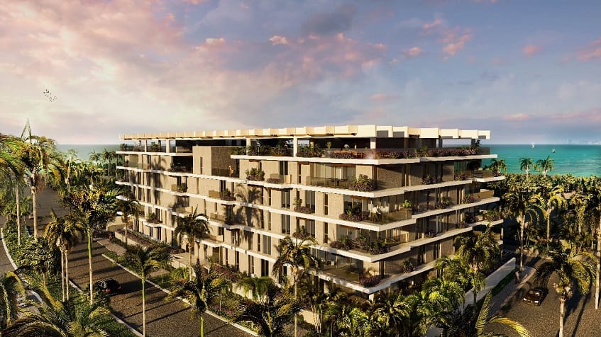 Corner view of white residential building surrounded by vegetation and ocean view at Alba Marina