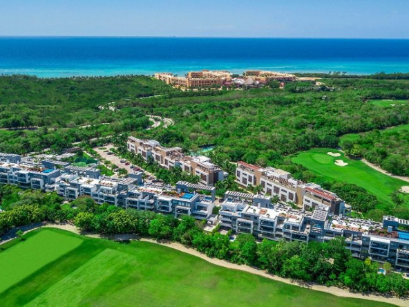 View of residential complex surrounded by golf course and ocean at Nick Price Residences