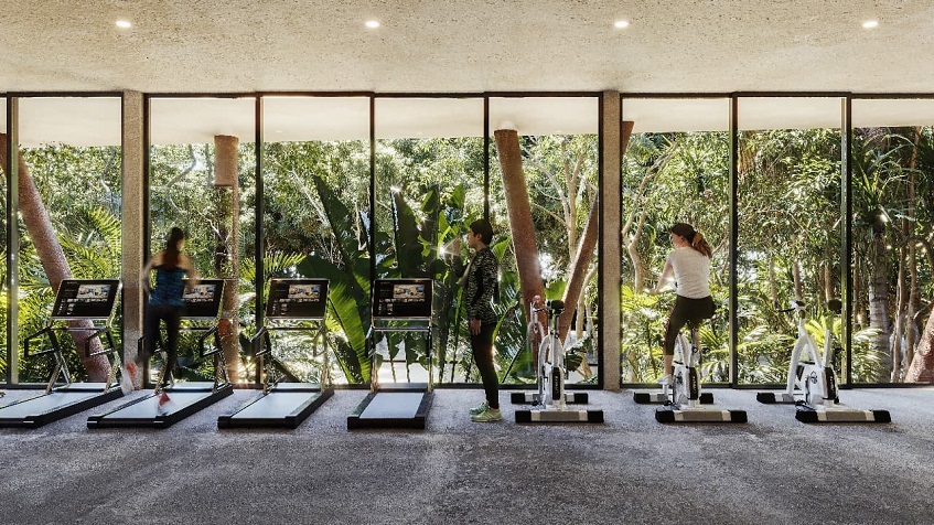 Gym and two women doing exercise on the bicycle and treadmill at Xibalba