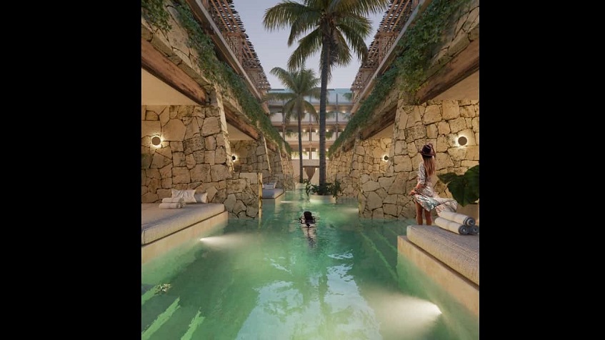 Long swimming pool between private terraces divided by walls and people relaxing at Alquimia Home Resort