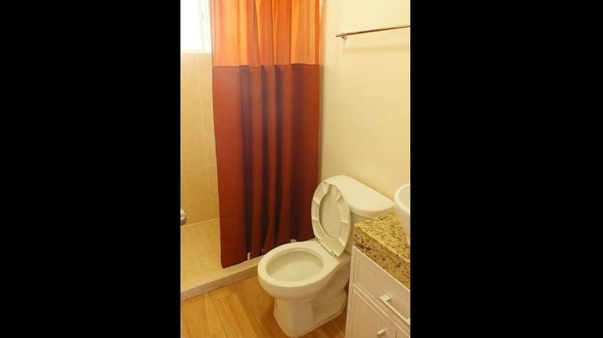 Bathroom with red shower curtain at Alcala Condos