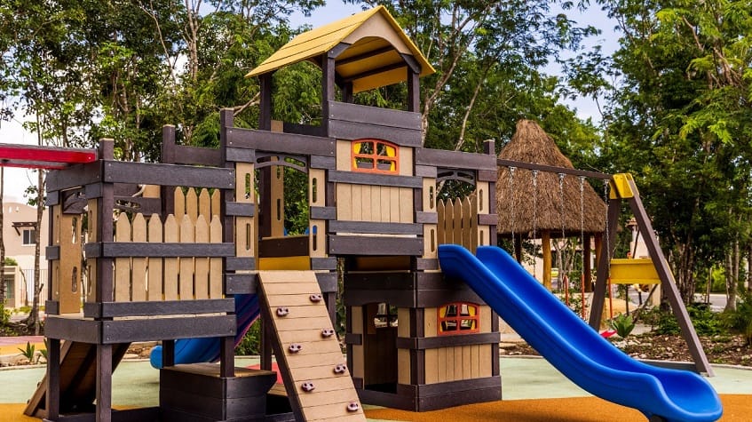 Kids playground with house slide and swings at Alcala Condos