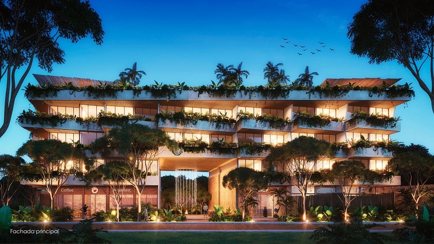 Residential building facade with green balconies during night time at Nequen Tulum