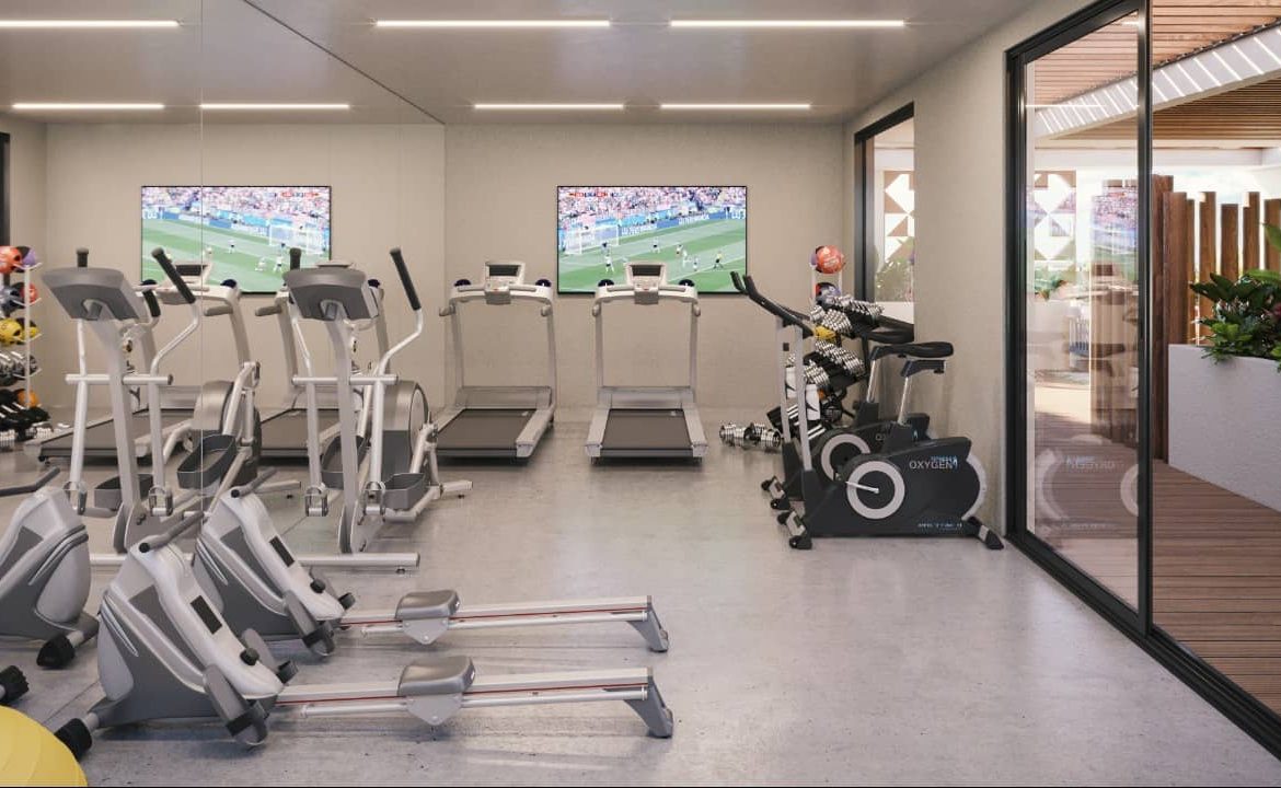 Gym with TV screens on the walls at Vibbe Luxury Condos