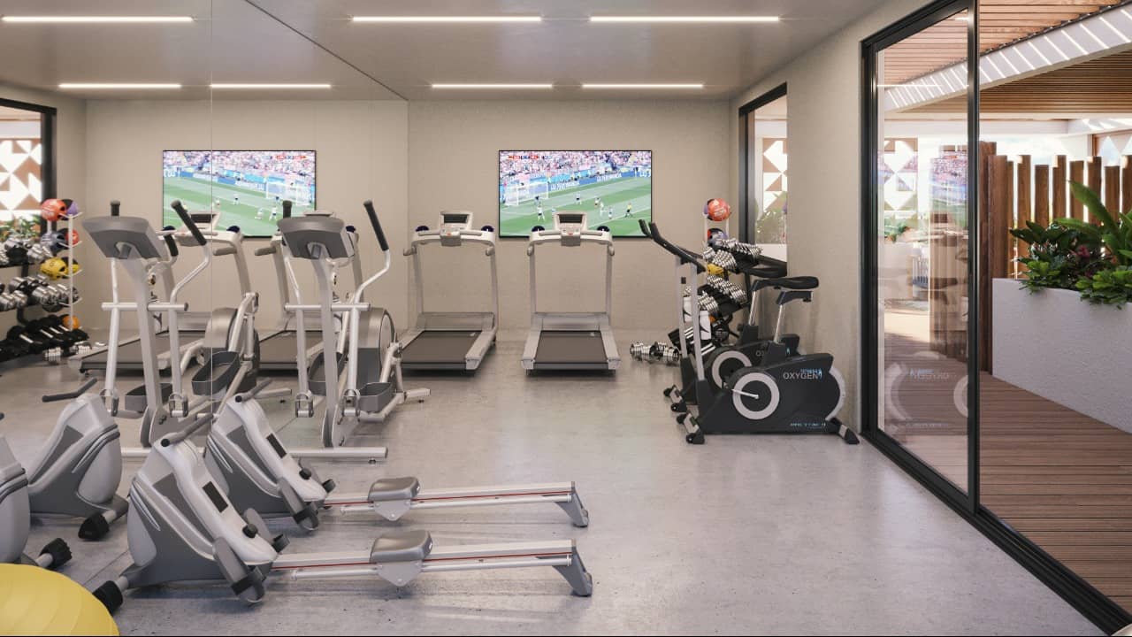 Gym with TV screens on the walls at Vibbe Luxury Condos