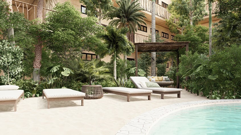 Residential building and sun beds by the pool at Elemental Tulum