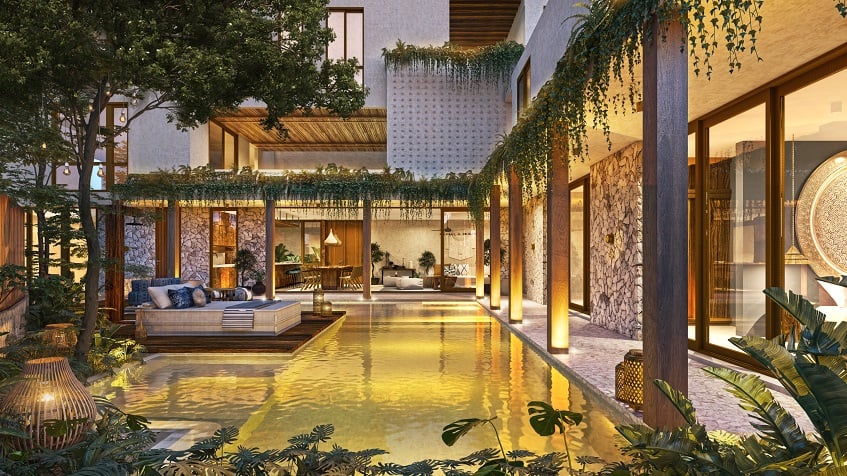 Ground floor pool surrounded by residential building terraces and vegetation at Mestiza Tulum