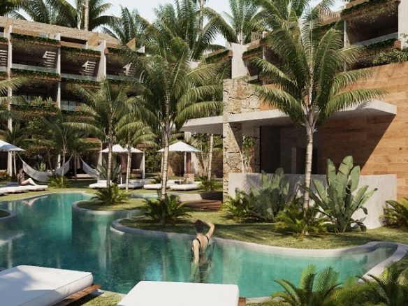 People swimming and hanging out around a pool and sundeck surrounded by vegetation at Naia Tulum