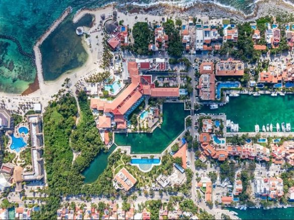 Aerial view of residential area with pools next to the ocean, marina dock at Secret Waters
