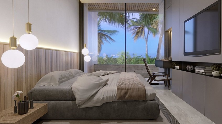 Bedroom with a bed in front of Tv and window view of ocean in the background at Distrito Puerto