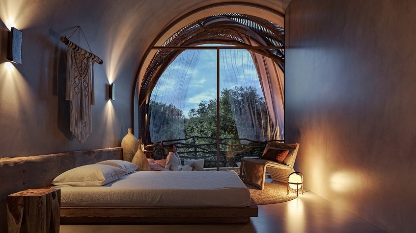Bedroom with a large round window and terrace at Selva Ambar Tulum