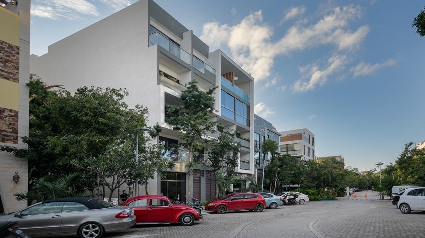Residential building facade and street view, parking with cars, motors and bicycles at Gaia Residence