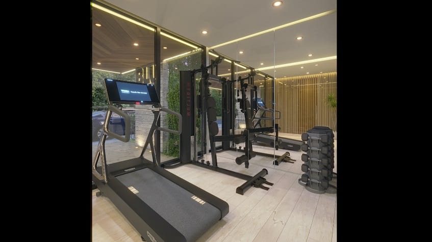 Gym room with a treadmill, weights and large mirror at Blu 38 Playa del Carmen