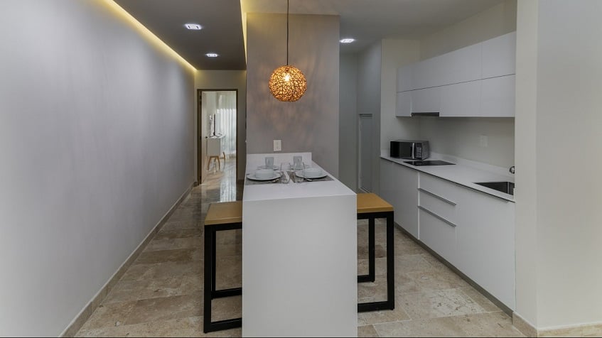 White kitchen and breakfast bar, corridor toward a room at Gaia Residence
