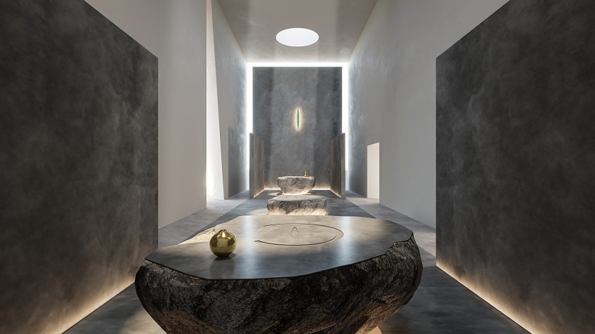 Three stone tables in a white and grey corridor illuminated at Icht Tulum
