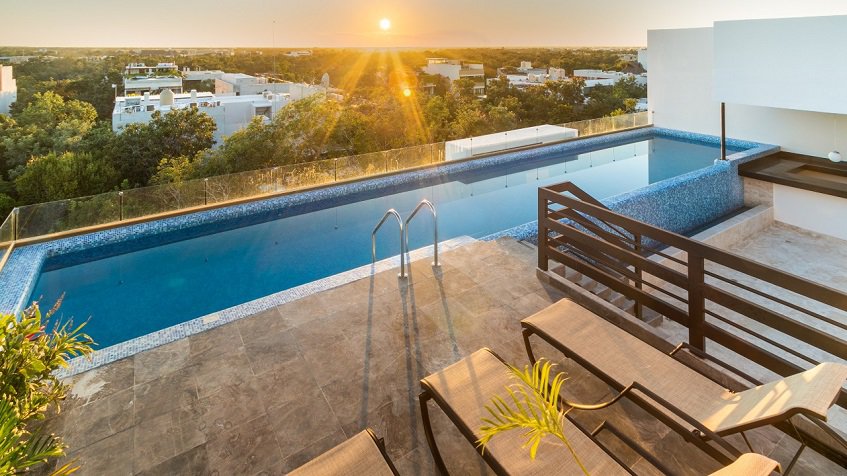 Rooftop pool, solarium, city view at sunset at Gaia Residence