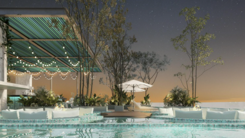 Pool by night time, white umbrellas and sofas at Altra Beach Condos