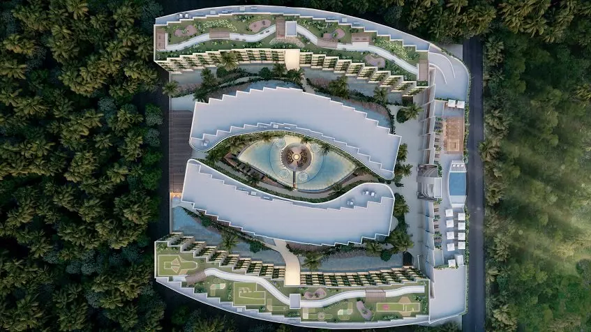 Top view of large residential complex rooftops and eye shape pool surrounded by a jungle at Dalai DK Tulum