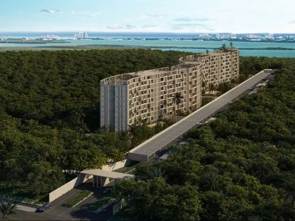 Aerial view of residential tall building surrounded by the jungle, ocean in the background at Okun Living Cancun