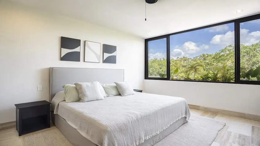 A bedroom with a bed and windows in Junglar Tulum