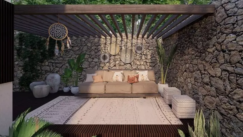 Terrace surrounded by stone wall and sofa, pergola at Sands Tulum