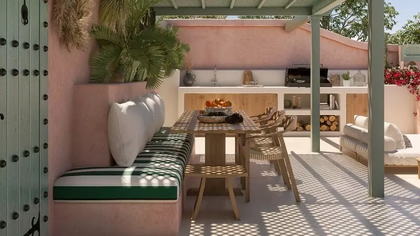 Rooftop table and chairs under a pergola, a grill with some cooking accessories and a sink at Pink Riad Tulum