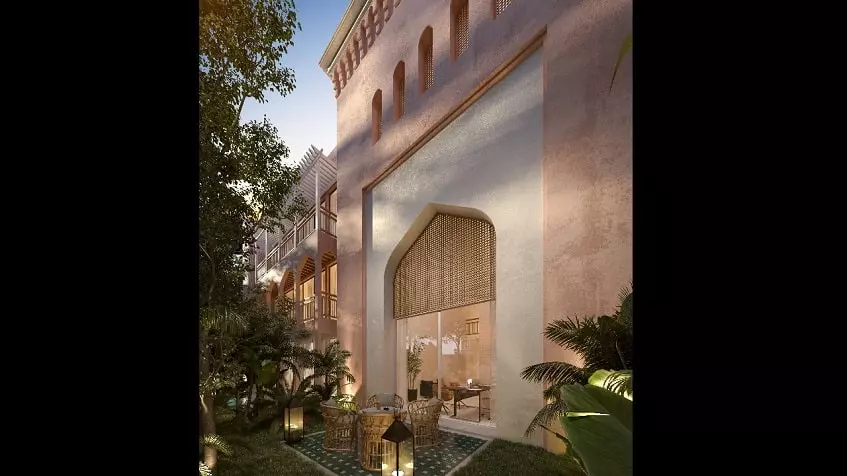 Residential building facade and backyard square terrace with table and chairs, garden lanterns at Pink Riad Tulum