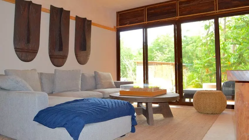 Living room with sofa corner, garden view tall window at Kiino Cozumel