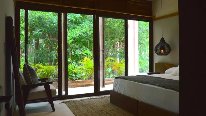 Bedroom with a glass wall, view to a garden, terrace at Kiino Cozumel