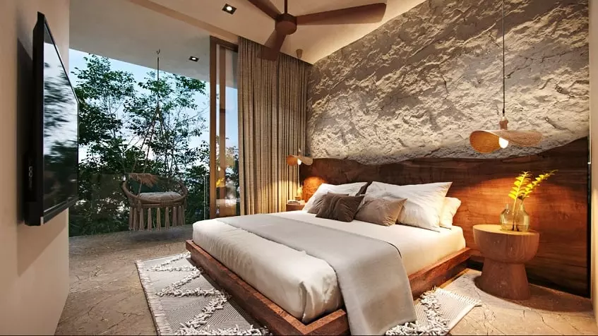 Bedroom with a bed in front of TV screen, swing in the terrace at Kukun Tulum Condos