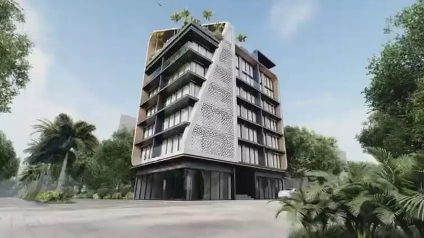 Corner view of residential building by a street and surrounded by a garden at Alizee Tower Playa del Carmen