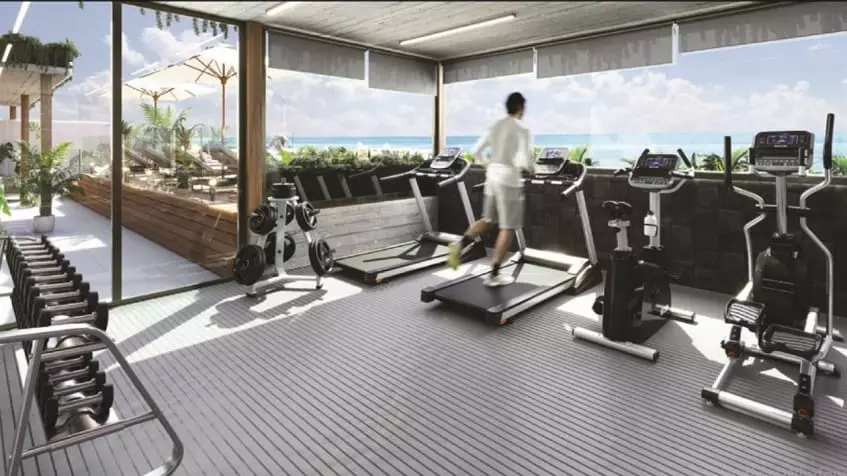 Gym room with a person doing exercise on a treadmill, ocean view at Ix Puerto Morelos Condos